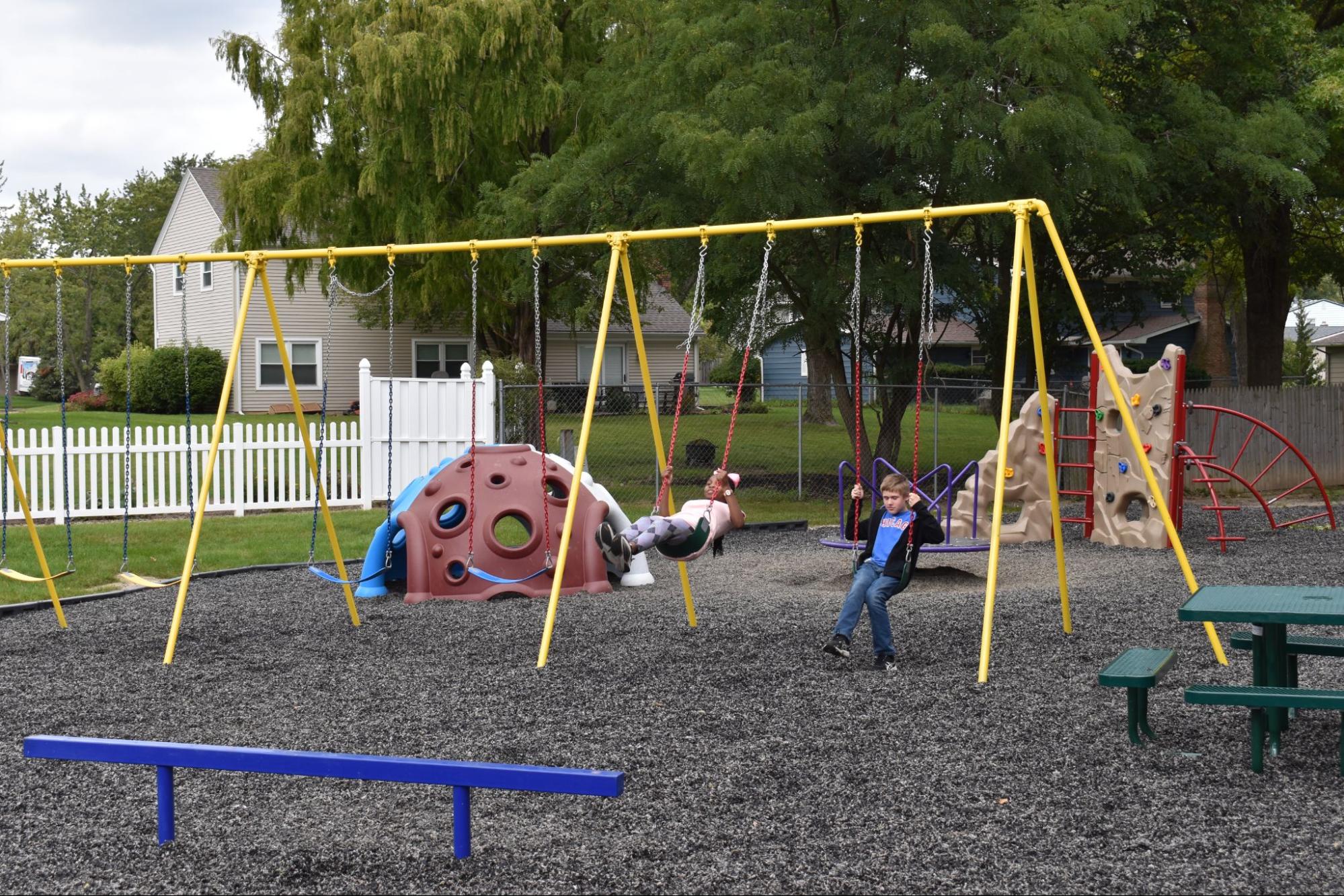 kids playing on tripod swing set